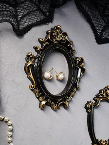 Detalle de un accesorio de marco en miniatura adornado de estilo vintage europeo negro y dorado
