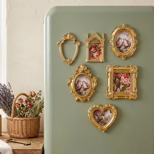 Vintage gold magnetic photo frames in heart and oval shapes on a green fridge.