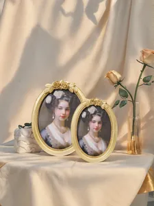 Set of two vintage oval gold resin photo frames with classical European portraits