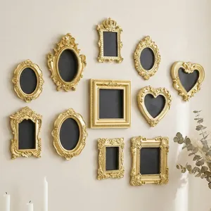 Various mini vintage gold embossed frames displayed on a wall as decorative magnets