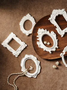 Künstlerische Darstellung weißer Mini-Resin-Fotorahmen auf strukturiertem Stoffhintergrund