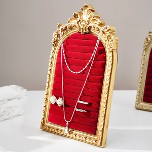 Macro shot of a vintage gold arched jewelry display frame with red velvet rows