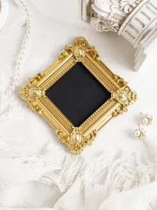 Macro detail of an ornate vintage golden embossed photo frame used as a fridge magnet