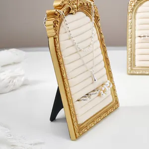 Vintage golden arched jewelry display frame with beige velvet slots for ring storage