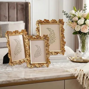 Elegantes Set aus drei goldenen Vintage-Fotorahmen mit Gänseblümchen-Dekor