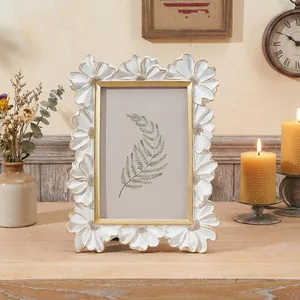 Primo piano della cornice vintage in resina con margherite e bordo dorato
