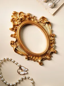 Détail d'un cadre photo baroque ovale en or antique pour accessoires de mise en scène