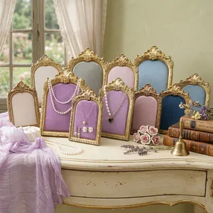 Detailed view of ornate vintage gold frame jewelry stands with colorful velvet inserts