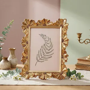 Detailansicht eines goldenen Vintage-Gänseblümchen-Fotorahmens mit Harzschnitzereien