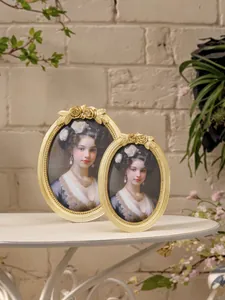 Close-up view of two vintage golden oval resin frames with intricate rose flower carvings