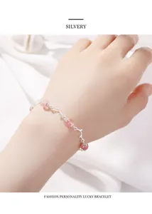 Dettaglio del bracciale con quarzo fragola e rami argentati indossato sul polso