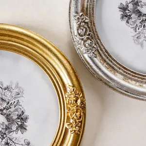Detailaufnahme des kunstvollen Rosenreliefs auf alten ovalen Bilderrahmen in Gold