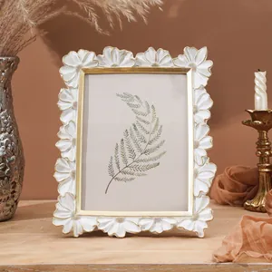 Dettaglio cornice in resina margherita bianca con elegante bordo dorato per decorazioni casa.