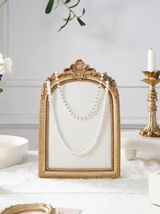 Detailed view of vintage resin photo frame jewelry display stand with elegant gold border.