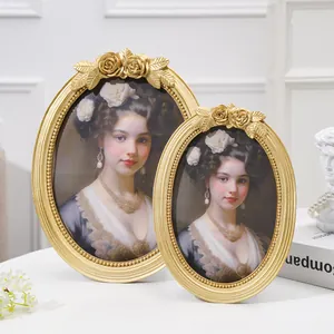 Elegant set of two oval vintage gold resin photo frames with rose carvings and portraits