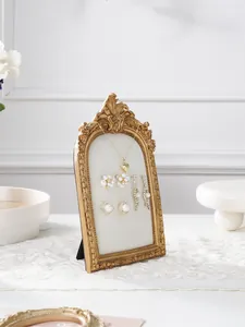 Close-up detail of the vintage gold resin jewelry display frame with soft velvet lining.