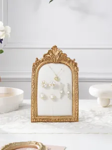 Exquisite baroque gold jewelry display stand detail featuring elegant white velvet backing.