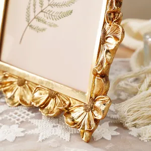 Detailansicht eines goldenen Fotorahmens aus Harz mit filigranen Gänseblümchen