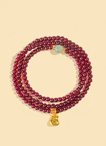Dettaglio del bracciale in granato 4mm a tre giri con ciondolo borsa portafortuna