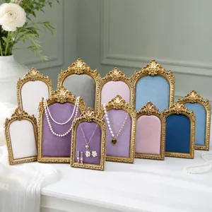 Collection of vintage ornate jewelry display stands with colorful velvet arched inserts.