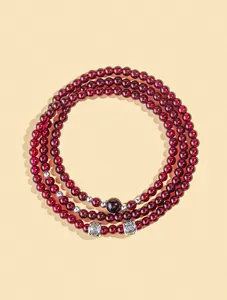 Vista dettagliata di perle di granato naturale da 4 mm su un bracciale a tre giri.