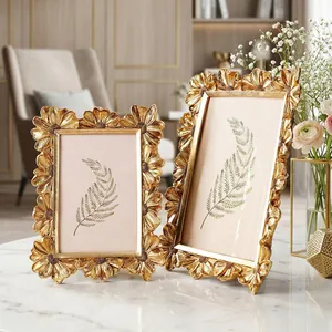 Detailansicht von eleganten goldenen Vintage-Fotorahmen mit Gänseblümchen-Muster aus Harz