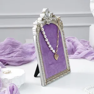 Retro vintage silver jewelry display frame with purple velvet backing for necklaces.
