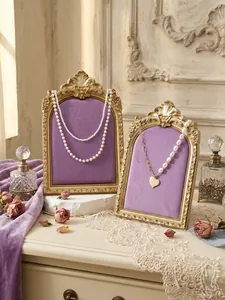 Detailed view of retro resin photo frame jewelry display stand with purple velvet backing.