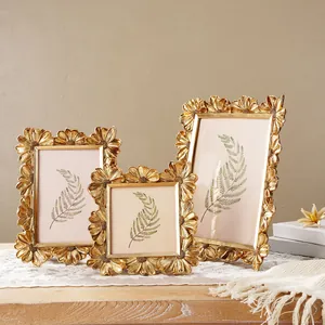 Elegantes Set aus drei goldenen Gänseblümchen-Fotorahmen im französischen Retro-Stil