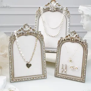 Vintage ornate silver arched jewelry display stands with velvet padding in an elegant set