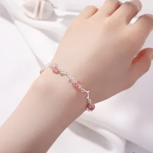 Elegante bracciale in quarzo fragola con maglie a vite argentate su un polso femminile.
