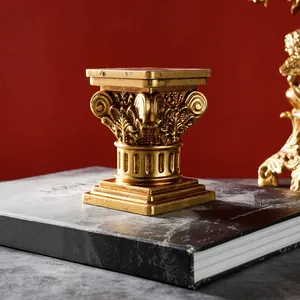 Primer plano de un candelabro dorado vintage con forma de columna romana y tallas detalladas