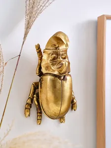Detalle de la decoración de pared de escarabajo rinoceronte de resina dorada con textura
