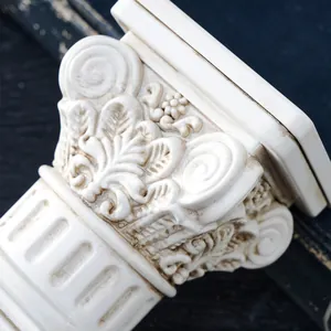Primer plano de un candelabro de columna romana blanco antiguo con tallas ornamentadas