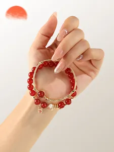 Detail of red agate and freshwater pearl double-layer bracelet with blessing charm