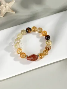 Primer plano de pulsera con cuentas de citrino natural y ojo de tigre con adorno