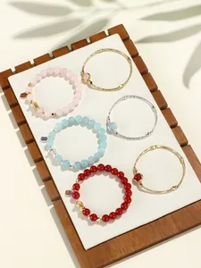 Detail shot of beaded crystal and agate bracelets with metal bangles on a tray.