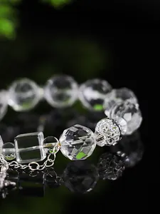 Detalle de una pulsera de cristal de cuarzo facetado con una cuenta de filigrana plata
