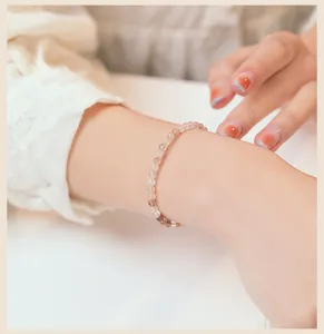 Vista detallada de una delicada pulsera de cuentas de cuarzo rutilado natural de 3mm en la muñeca
