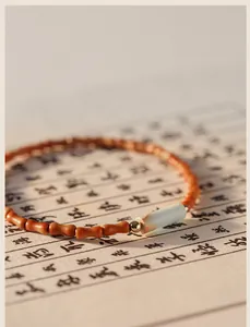 Close-up of minimalist olive pit bead bracelet featuring a cylindrical Shoushan stone bead