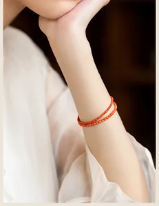 Close-up detail of double-layer 3mm natural red agate beaded bracelet worn on woman's wrist