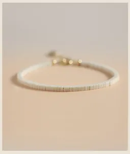 Close-up of minimalist white jade beaded bracelet with elegant gold-tone clasp