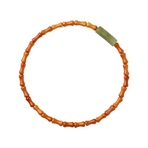 Zen-style olive pit bracelet with a cylindrical green shoushan stone bead on white.
