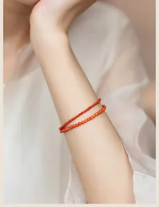 Close-up shot of 3mm natural red agate bead bracelets stacked on a woman's wrist