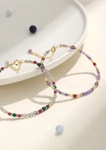 Detalle de una delicada pulsera de cuentas de cristal multicolor con piedra de luna