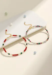 Detalle de pulseras de cuentas de colores con piedra de luna, malaquita y cierres dorados