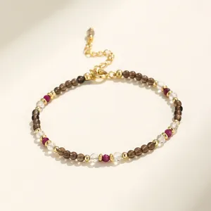 Primer plano de una pulsera de cuentas multicolores con herrajes dorados y cristales