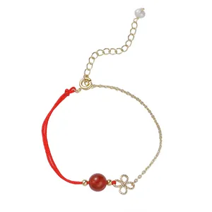 Minimalistisches Armband aus roter Kordel und Goldkette mit roter Perle und Blumenanhänger