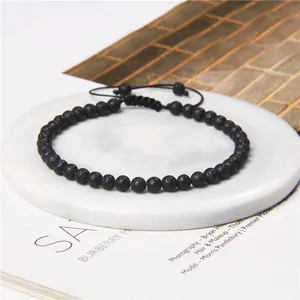 Macro detail of 4mm black lava stone bead bracelet with adjustable woven strap