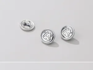 Dettaglio macro di bottoni testa di mucca in argento sterling S925 opaco